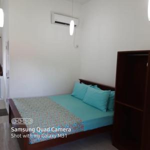 a small bedroom with a bed with blue sheets at Transit Studio Katunayake in Katunayake