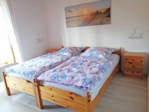 a bedroom with a wooden bed with a colorful comforter at Ferienwohnung "Luv" Grube Ostsee in Grube