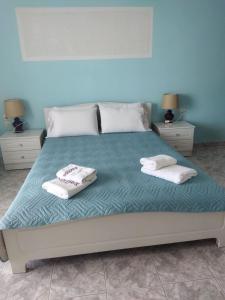 a bedroom with a bed with two towels on it at Kiknos Studios in Kalamaki Heraklion