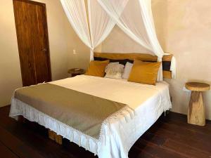 a bedroom with a large bed with a canopy at Lodge Tzunum Jade in Tulum