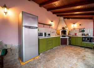 クラペッツにあるКъща за гости Сашаの広いキッチン(緑のキャビネット、冷蔵庫付)