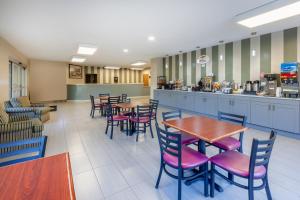 a restaurant with tables and chairs and a counter at Super 8 by Wyndham La Grange KY in La Grange