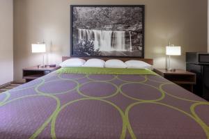 1 cama grande en una habitación de hotel con 2 lámparas en Super 8 by Wyndham La Grange KY, en La Grange
