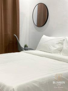 una camera con letto bianco e specchio di Blumeen Lite 1 - Comfortable Budget Home 3BR a Kuala Terengganu