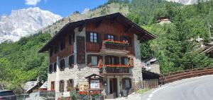 a house with flowers on the side of a road at Hotel Dente Del Gigante in Courmayeur