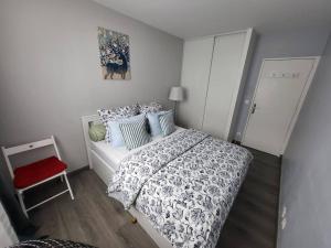 a bedroom with a bed and a red chair at Appartement meublé de 81 m² Champigny-Sur-Marne in Champigny-sur-Marne