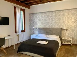 Dormitorio con cama, escritorio y TV en Casa Giardini, en Venecia