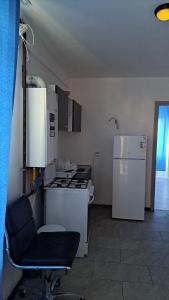 Il comprend une cuisine équipée d'une cuisinière, d'un réfrigérateur et d'une chaise. dans l'établissement TC Vest Residence, à Leţcani