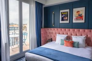 PLEY Hotel في باريس: غرفة نوم بسرير كبير وبلكونة