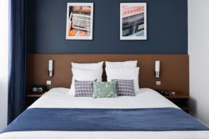 a bedroom with a bed with blue walls and pillows at PLEY Hotel in Paris