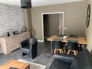 uma sala de estar com mesa e cadeiras em Appartement tout confort dans une résidence calme em Givet