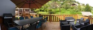 a deck with a table and chairs and an umbrella at Maison Gite Le Bressaud in La Bresse