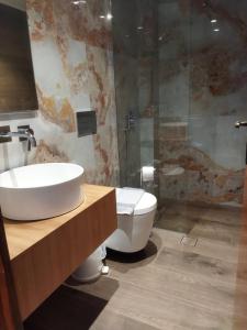 a bathroom with a sink and a toilet and a shower at Kiknos Studios in Kalamaki