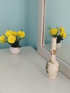dos jarrones con flores amarillas sentados en una mesa en Kiknos Studios, en Kalamaki