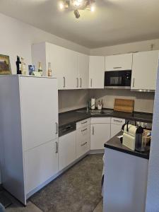 eine Küche mit weißen Schränken und einer Arbeitsplatte in der Unterkunft City Appartement 1 Hannover Altstadt in Hannover
