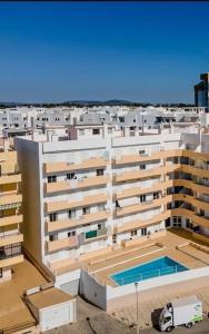 een luchtzicht op een gebouw met een zwembad bij Vilamoura-Quarteira Beaches Apt with pool and sea view in Quarteira