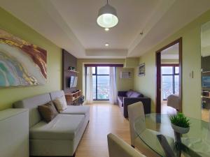 uma sala de estar com um sofá e uma mesa de vidro em Suite 1 Bedroom with Seaview-Horizons 101 em Cebu