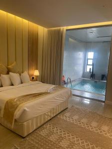 a bedroom with a large bed and a swimming pool at منتجع واحة النخيل in Ash Shafa