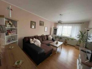 a living room with a brown couch and a table at 3 izbový byt in Liptovský Mikuláš