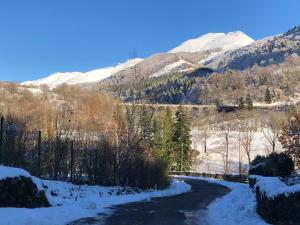 a snow covered road with snowy mountains in the background at SUPER LIORAN LA MAISONETTE à 5 km de la station in Saint-Jacques-des-Blats