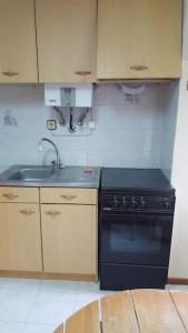 a kitchen with a black stove and a sink at Casa da Catraia - Remodelação recente nos quartos in Póvoa de Midões