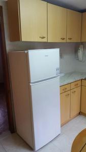 a kitchen with a white refrigerator in a room at Casa da Catraia - Remodelação recente nos quartos in Póvoa de Midões