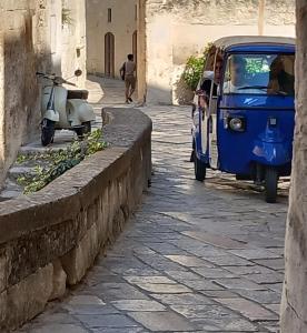 a small car and a scooter parked on a street at Dimora 1919 Luxury Loft in Matera
