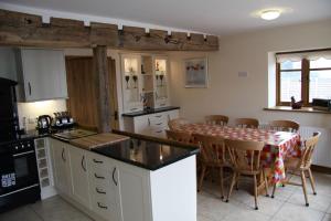 a kitchen with a table and chairs and a kitchen with white cabinets at The Granary Self Catering Cottage in Shrewsbury