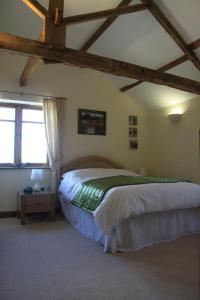 ein Schlafzimmer mit einem Bett in einem Zimmer mit Holzdecken in der Unterkunft The Granary Self Catering Cottage in Shrewsbury