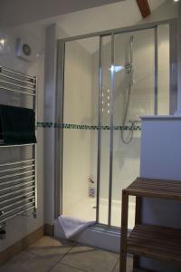 um chuveiro com uma porta de vidro na casa de banho em The Granary Self Catering Cottage em Shrewsbury