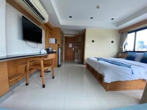 Ban Zong KatiamにあるL18 residence แอลสิบแปด เรสซิเดนซ์のベッドルーム(ベッド1台、デスク、テレビ付)
