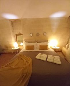 a bedroom with a large bed with two towels on it at Dimora 1919 Luxury Loft in Matera