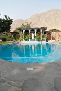 a large swimming pool with a mountain in the background at Hacienda Santa María de Cieneguilla in Cieneguilla