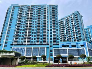 a large blue building with trees in front of it at Residential Resort Condo by the Bay in Manila