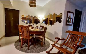 a dining room with a wooden table and chairs at Residential Resort Condo by the Bay in Manila