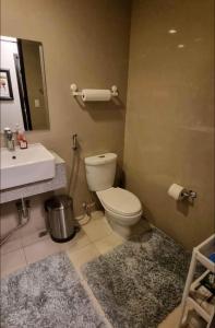 a bathroom with a toilet and a sink and a mirror at Residential Resort Condo by the Bay in Manila