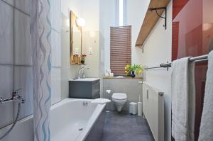 a bathroom with a tub and a toilet and a sink at Quiet Courtyard Apartment (PB1) in Berlin