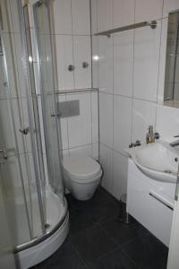 ein Bad mit einer Dusche, einem WC und einem Waschbecken in der Unterkunft Ferienwohnung&Aparts By kispet group hotels in Oberhausen in Oberhausen