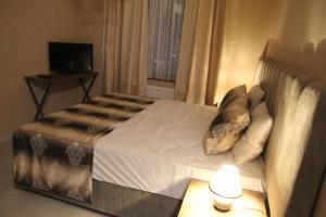 ein Schlafzimmer mit einem Bett mit einer Lampe und einem Fenster in der Unterkunft Ferienwohnung&Aparts By kispet group hotels in Oberhausen in Oberhausen