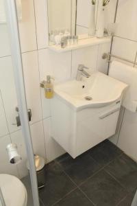 Baño blanco con lavabo y aseo en Ferienwohnung&Aparts By kispet group hotels in Oberhausen en Oberhausen