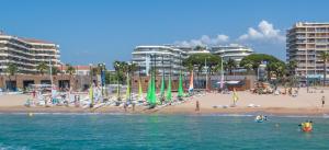 a beach with a group of people and buildings at Les Cactus Fréjus Plage in Fréjus
