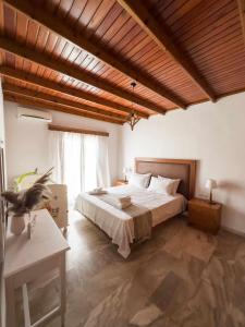 Kámpos的住宿－Villa Aelia，一间卧室设有一张大床和木制天花板
