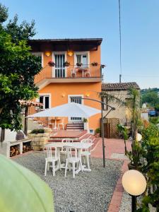 uma mesa com um guarda-chuva em frente a uma casa em Le Maioliche em Saponara Villafranca