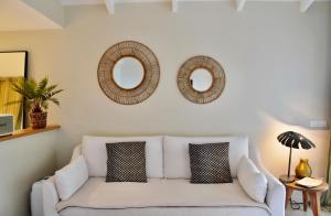 uma sala de estar com um sofá branco e dois espelhos em Franca St Jean em Saint-Jean