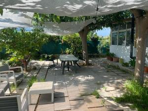 un patio con mesa y sillas bajo una pérgola en El Huerto en Valencia