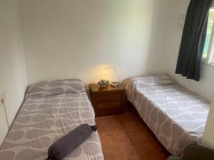 1 dormitorio con 2 camas y mesita de noche con lámpara en El Huerto en Valencia