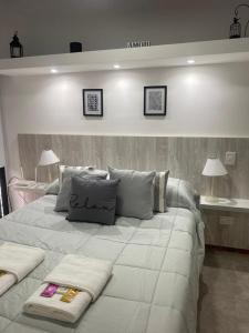 1 cama blanca grande con 2 almohadas en DEPARTAMENTO VERA MUJICA 4 COHERA PROPIA INCLUIDA en Rosario