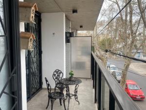 a patio with a table and chairs on a balcony at DEPARTAMENTO VERA MUJICA 4 COHERA PROPIA INCLUIDA in Rosario