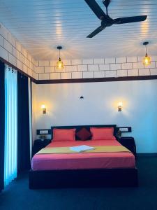 Schlafzimmer mit einem Bett mit roten Kissen und einer Decke in der Unterkunft Linn View Home Stay Munnar in Munnar