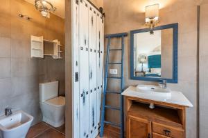 a bathroom with a sink and a toilet and a mirror at Casa Rural Olavide 